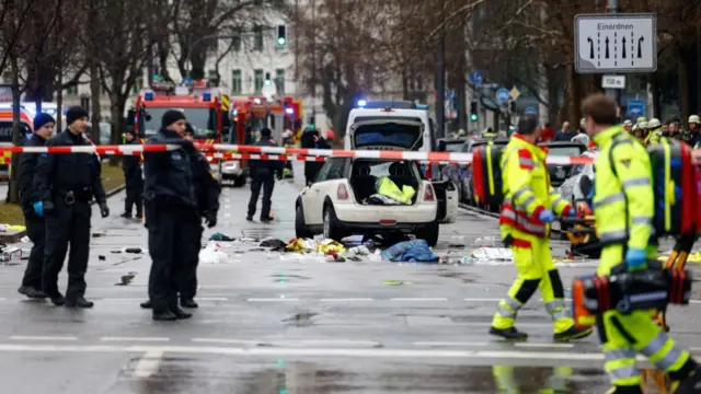 Members of the emergency services work at the scene where a car drove into the crowd