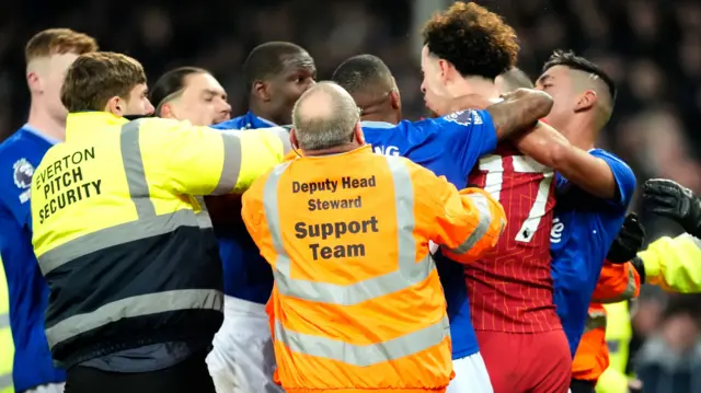 Liverpool's Curtis Jones and Everton's Abdoulaye Doucoure are separated by team-mates and members of the ground staff following a clash