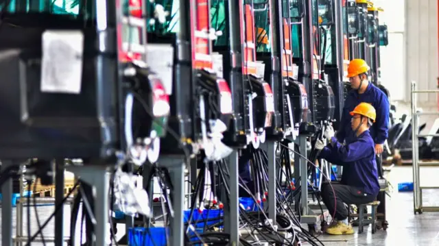 Workers assemble vehicles in China