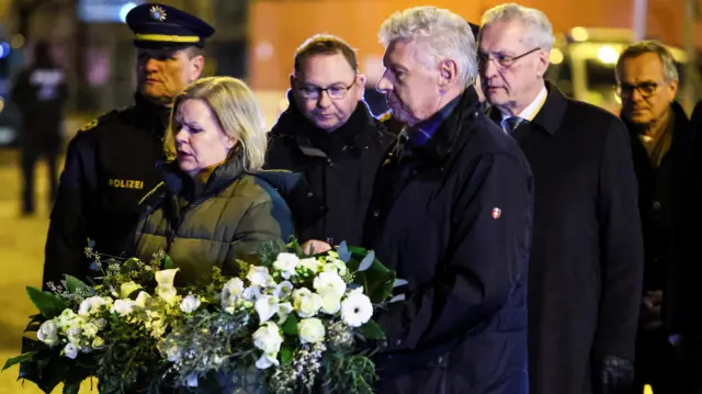 Interior Minister Nancy Faeser, Munich mayor Dieter Reiter, Bavarian interior Minister Joachim Herrmann and public sector workers union Verdi's leader Frank Werneke hold white floral arrangements as they pay their respects