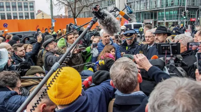 Markus Soder (right, in hat) speaking to reporters in Munich earlier