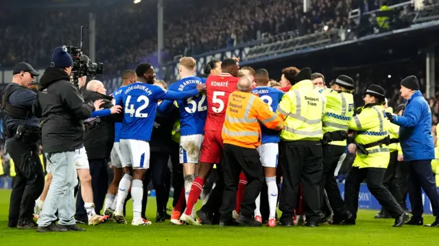 Liverpool's Curtis Jones and Everton's Abdoulaye Doucoure are separated by team-mates and members of the ground staff following a clash