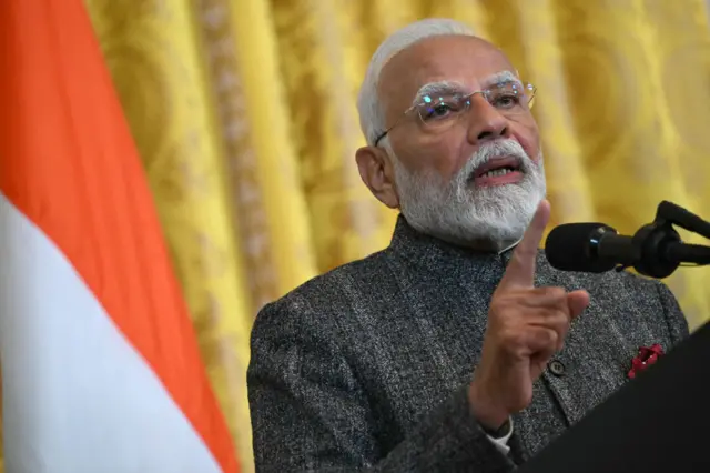 Man speaks at podium and points his finger
