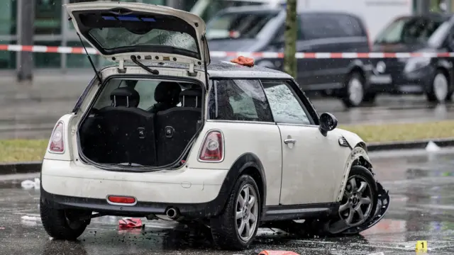 A damaged white Mini Cooper with the boot open