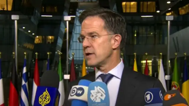 Mark Rutte speaking to press ahead of summit, he has five mics from international broadcasters in front of him