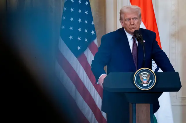 Man in suit at podium through blurry shot