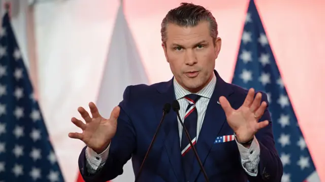 US Secretary of Defence Pete Hegseth speaking at a news conference in front of US flags