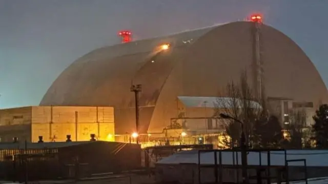 An image of a dome over the reactor as seen from the outside, a small fire can be seen on the exterior