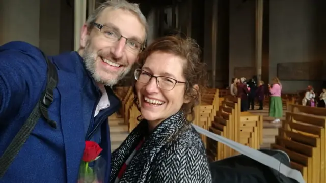 Rosie with her other half, holding a rose, inside the cathedral