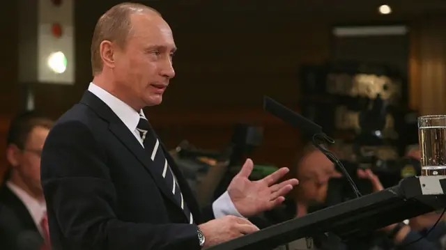 A  younger Vladimir Putin stands at a lectern in Munich in 2007