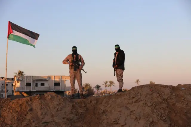 Hamas militants stand guard before the release of hostages held in Gaza since the deadly October 7, 2023 attack, as part of a ceasefire and a hostages-prisoners swap deal between Hamas and Israel in Khan Younis