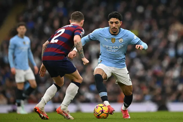 Kieran Trippier (L) vies with Manchester City's Egyptian striker Omar Marmoush