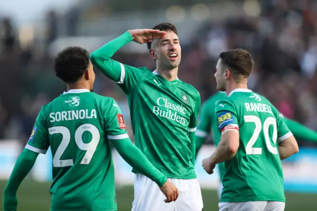 Plymouth striker Ryan Hardie (centre) salutes the crowd after scoring v Liverpool, flanked by two team-mates