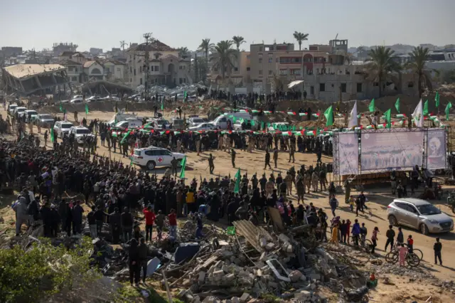 Red Cross vehicles wait at the spot where Hamas militants are expected to hand over Israeli hostages in Khan Yunis in the southern Gaza Strip