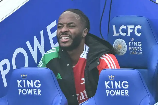 Raheem Sterling takes his seat on the bench