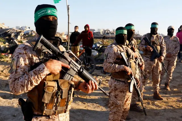 Hamas militants stand guard before the release of hostages held in Gaza since the deadly October 7, 2023 attack, as part of a ceasefire and a hostages-prisoners swap deal between Hamas and Israel in Khan Younis