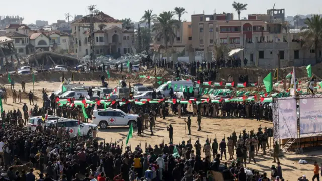 Red Cross vehicles wait at the spot where Hamas militants are expected to hand over Israeli hostages in Khan Yunis