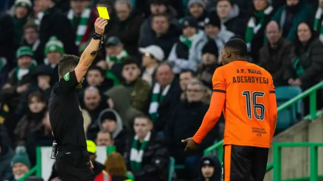 Dundee United's Emmanuel Adegboyega (R) is shown a yellow card by Referee Nick Walsh during a William Hill Premiership match between Celtic and Dundee United at Celtic Park, on February 15, 2025, in Glasgow, Scotland.  (Photo by Craig Williamson / SNS Group)