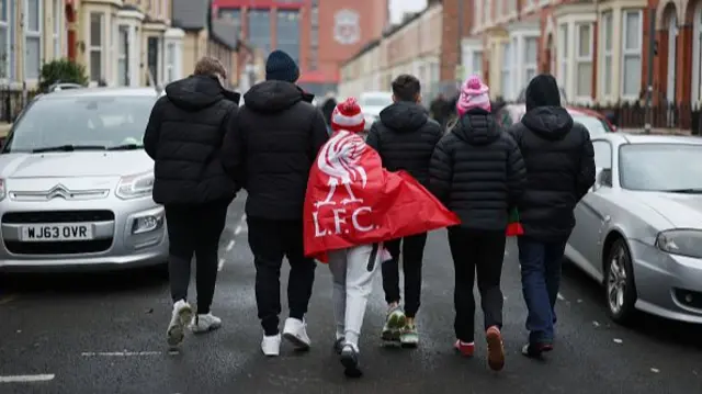 Fans of Liverpool make their way to the stadium