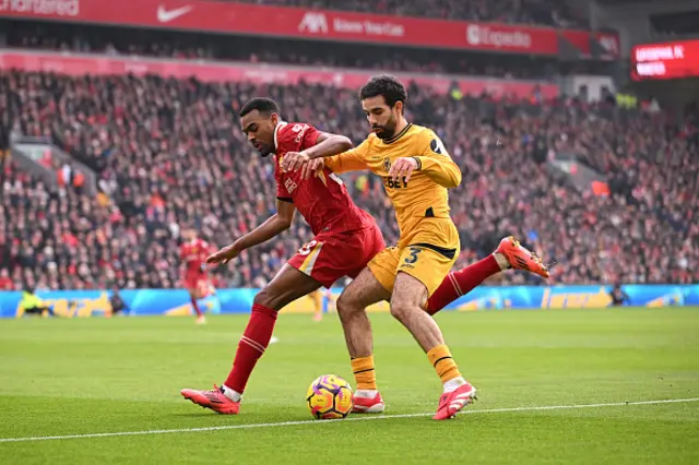 ayan Ait-Nouri of Wolverhampton Wanderers runs with the ball whilst under pressure from Ryan Gravenberch