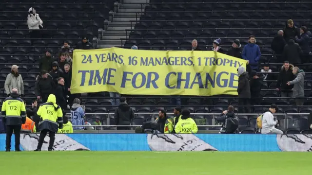 Tottenham fans hold a banner which reads: "24 years, 16 managers, 1 trophy - time for change"