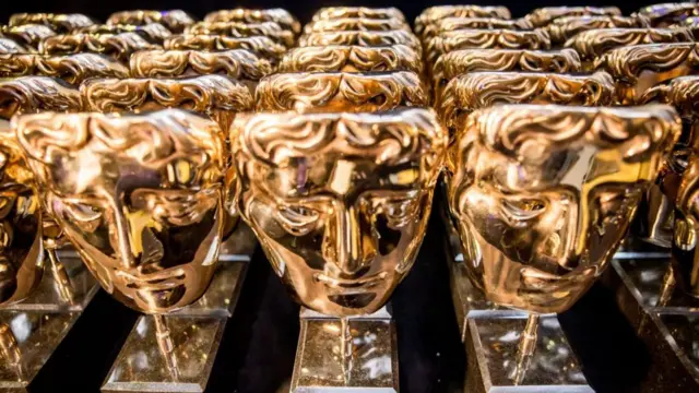 Golden Bafta film awards lined up in rows