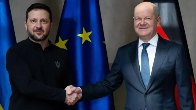 German Chancellor Olaf Scholz (R) and Ukrainian President Volodymyr Zelensky (L) shake hands as they meet for talks at the Munich Security Conferenc