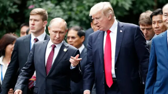 US President Donald Trump (R) and Russia's President Vladimir Putin chat as they walk together