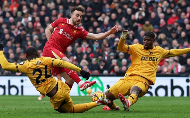 Liverpool's Diogo Jota in action with Wolverhampton Wanderers' Toti Gomes and Emmanuel Agbadou