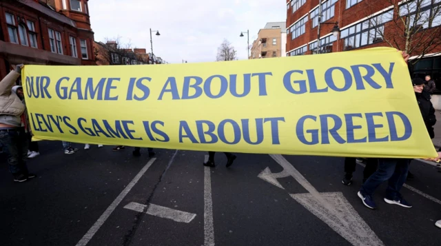 Tottenham Hotspur fans with a banner in protest to chairman Daniel Levy outside the stadium