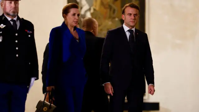 French President Emmanuel Macron (right) walks with Denmark's Prime Minister Mette Frederiksen as she leaves the meeting