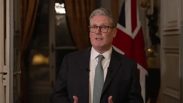 Keir Starmer speaking in front of a Union Jack flag