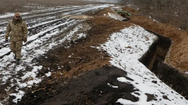 A Ukrainian soldier walks near a newly built trench on Friday in north-east Ukraine