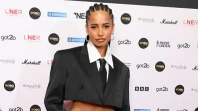 TV personality Amber Gill wearing a crop top style suit.