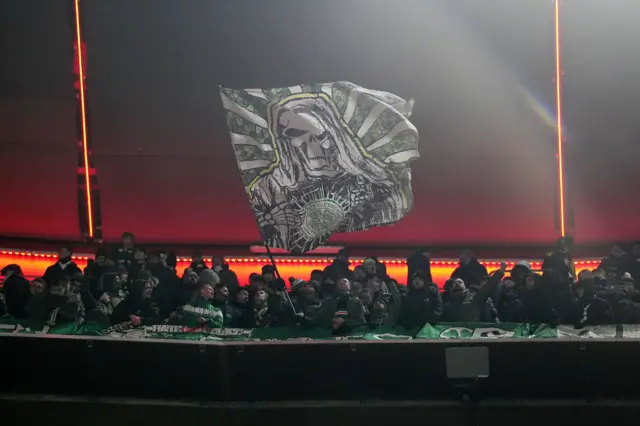 Celtic fan waves a flag in the stands