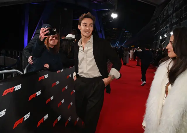 Mercedes driver George Russell poses for a selfie on the red carpet for F1 75 Live
