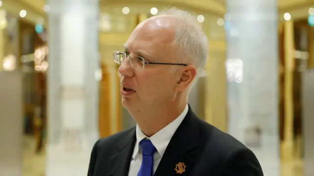 Kirill Dmitriev speaks to members of the delegation and journalists