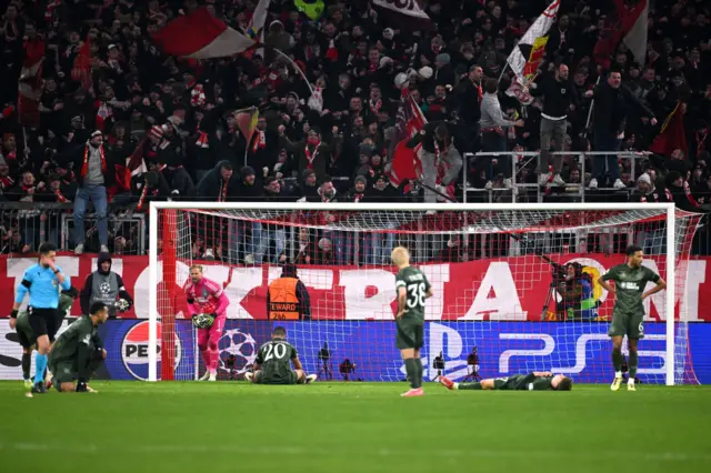 Celtic players lie strewn across the pitch after Bayern's late winner