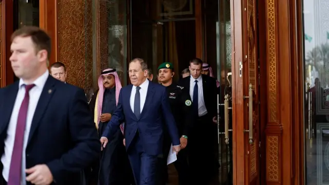 Russian Foreign Minister Sergei Lavrov leaves a hotel, surrounded by his entourage