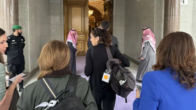 Several people walking into a building in Saudi Arabia