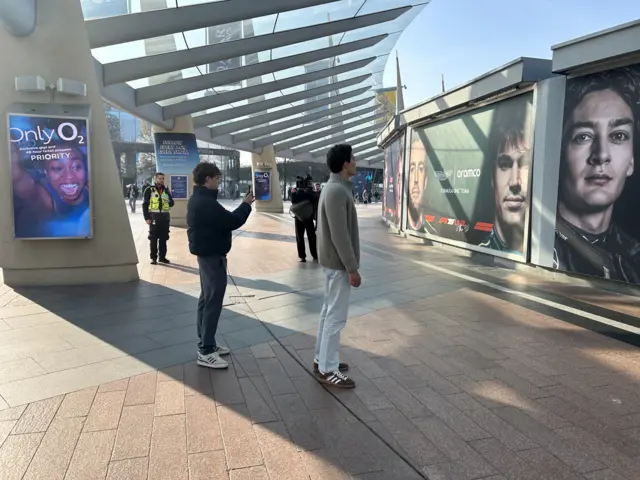 Andrea Kimi Antonelli and George Russell take photos outside the O2 arena.