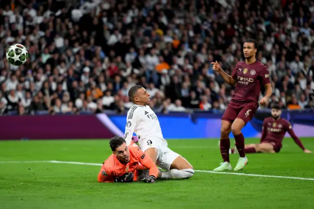 Kylian Mbappe of Real Madrid collides with Ederson of Manchester City