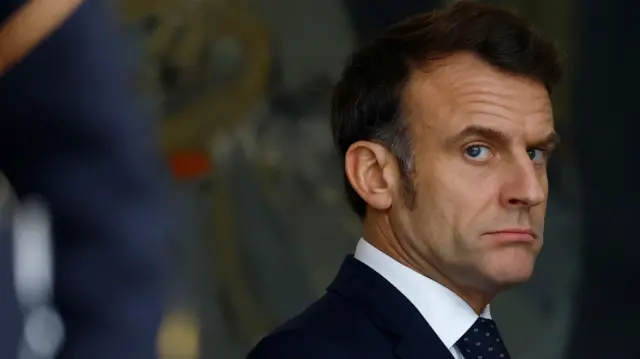 Emmanuel Macron pictured with a serious expression in a black suit and tie on Wednesday