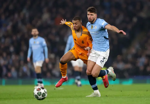 Kylian Mbappe and Ruben Dias vie for the ball