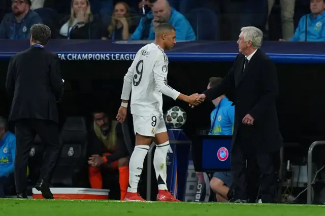 Kylian Mbappe is embraced by Carlo Ancelotti