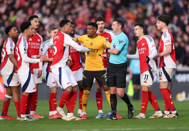 Arsenal players surround Michael Oliver after he sent off Myles Lewis-Skelly