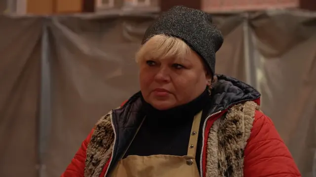 Alina wears winter clothes as she works at her market stall in Kyiv