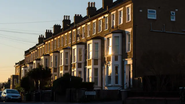 A shaft of light across a row of terraced houses