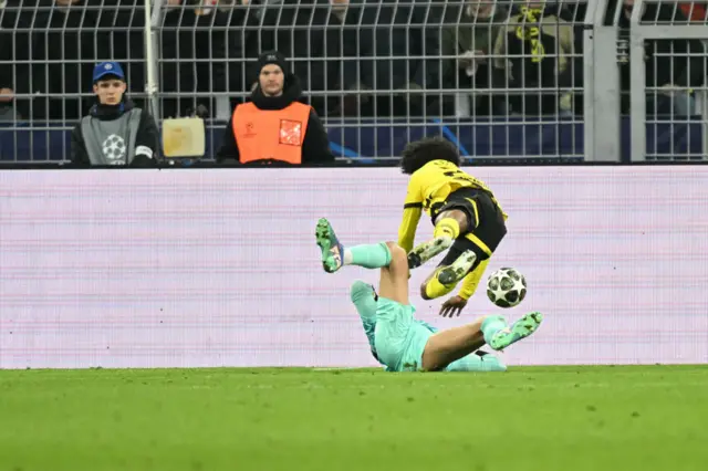 Portuguese goalkeeper #24 Rui Silva fouls Dortmund's German forward #27 Karim Adeyemi.