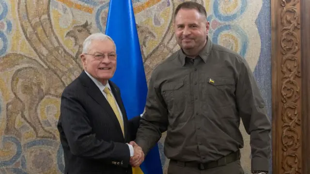 Left: Kellogg shakes hands with Yermak, right, in front of a Ukrainian flag